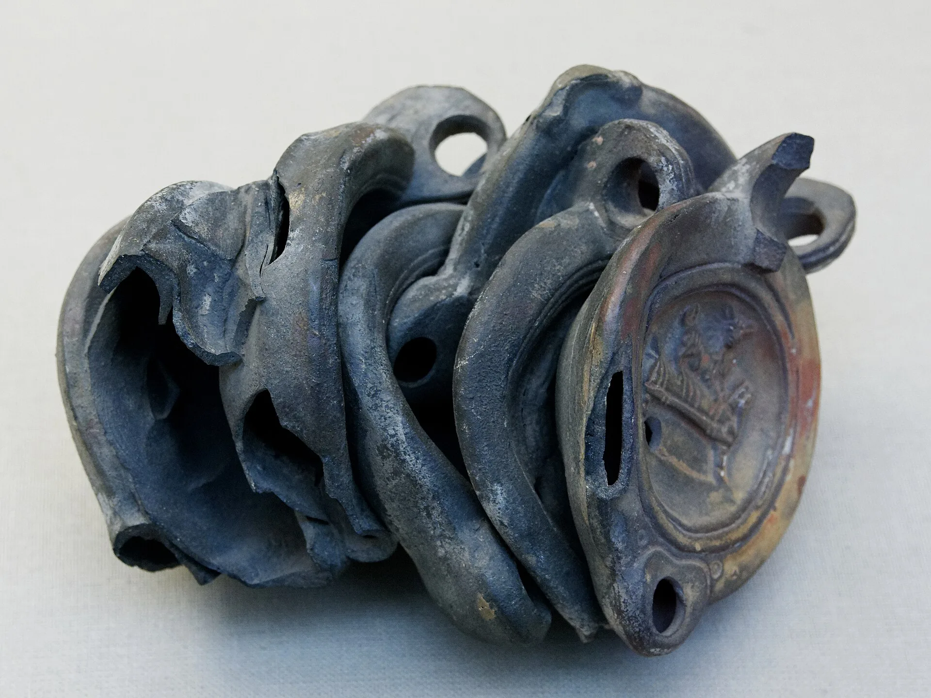 Misfired clay lamps, fused together in the firing kiln. Roman work. What do an ancient Greek kiln and a long wood firing teach about solo studio mistakes?