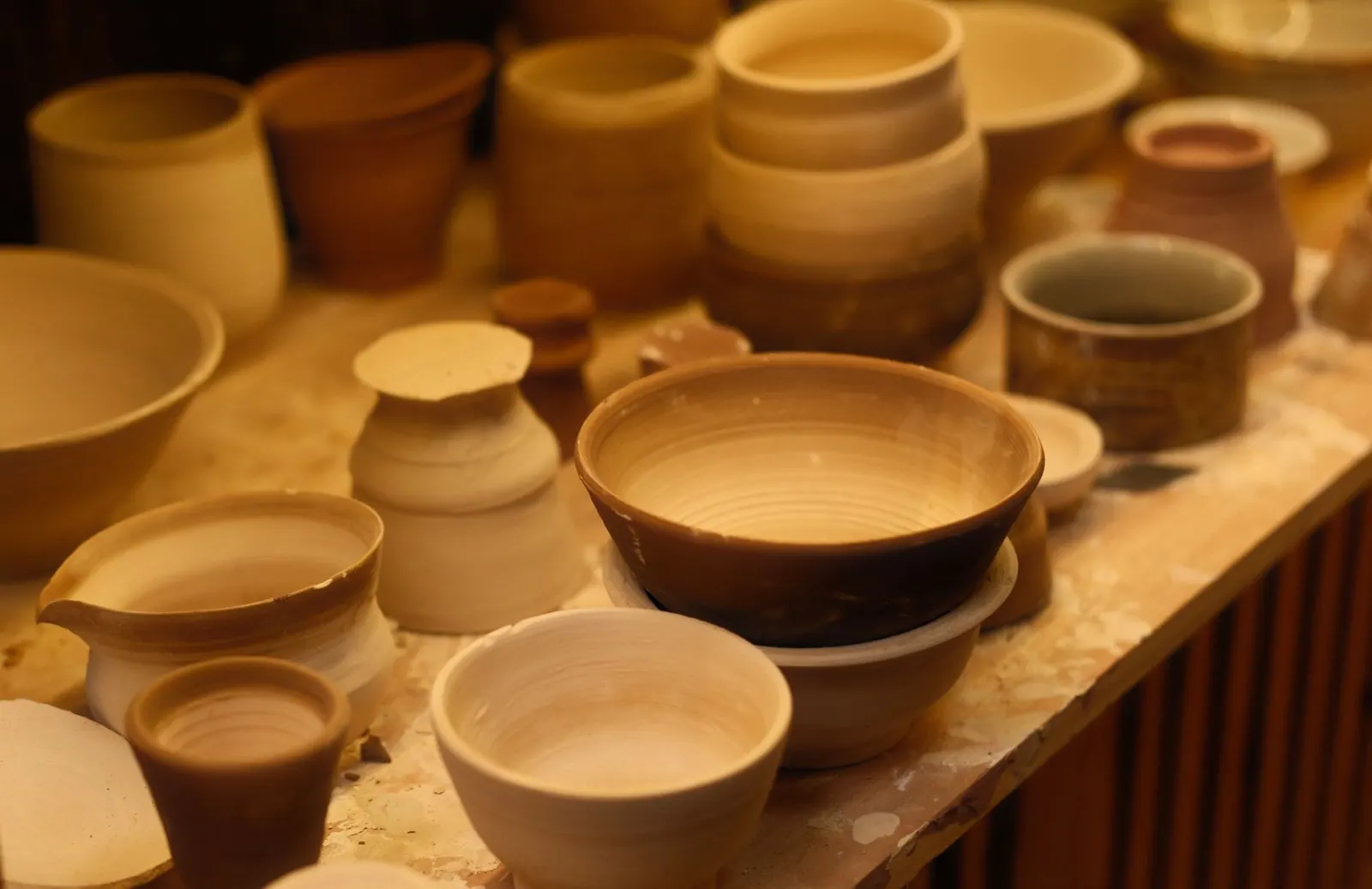A collection of handcrafted ceramic bowls displayed in an artisan pottery studio with soft lighting. How to photograph and present studio ceramics
