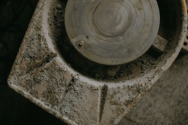 A close-up of a rustic clay-covered pottery wheel, showcasing texture and artisanal craft. Beginner pottery wheels storage: a dry, dust-free routine