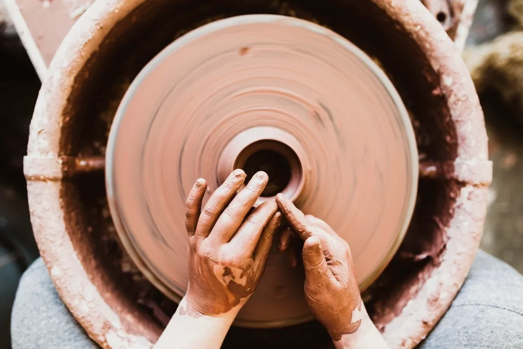 person's hands crafting pottery spinning. Good pottery habits compared with the small mistakes that waste gear at home