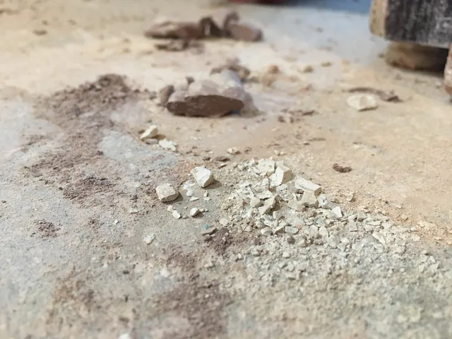 Different size grains of clay dust on the floor of a ceramics studio. Small ceramics projects expert tips: recycle clay, control dust